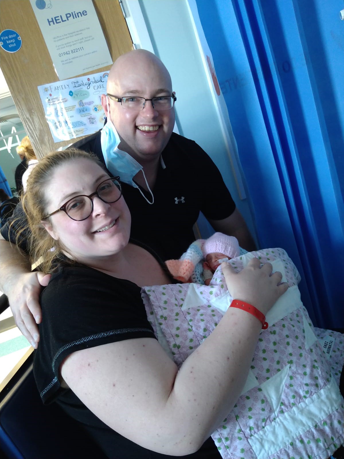 Man and woman smiling with new baby